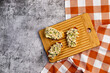 Tuna Salad open faced Sandwiches on a rectangular cutting wooden board on a dark grey background. Top view, flat lay