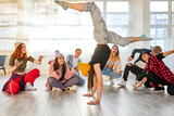 break dancer woman showing different tricks and movements while dancing in the studio, flexible and sportive female on the floor