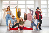 youth having fun in choreography class, posing with female trainer in studio, hip-hop dancers