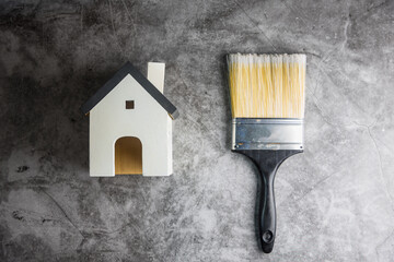 Wall Mural - Wooden white house toy and construction tools on Gray-black cement floor background with copy space.Real estate concept, New house.Home repair concept