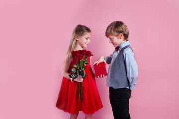 Wall Mural - Valentines day surprise. Little boy in love giving cute girl red rose ,