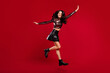 © deagreez - Full length profile side photo of charming lady raise hands wings jump up wear boots isolated on red color backgrounds