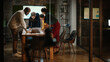 © Gorodenkoff - Diverse Multiethnic Team are Having a Conversation in a Meeting Room Behind Glass Walls in a Creative Office. Colleagues Lean On a Conference Table and Discuss Business, App User Interface and Design.