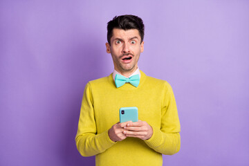Wall Mural - Portrait of brunet stressed guy hold telephone hand face wear yellow sweater isolated on pastel lilac color background