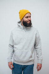 Handsome hipster guy with beard wearing gray blank hoodie with space for your logo or design. Mockup for print