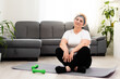 © Angelov - Closeup portrait of active senior woman doing dumbbell exercises at home, smiling.