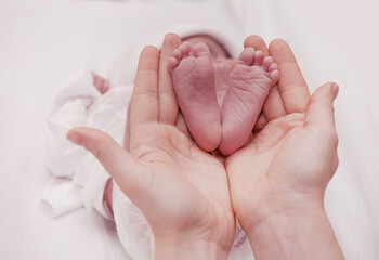 Mother holding her little baby's feet, close up.Concept skin examination by a doctor