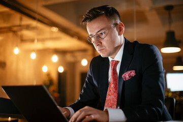 Young businessman using laptop in his office. Handsome man working at his workplace