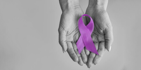 world cancer day inscription. healthcare and medicine concept - girl hands holding purple cancer awa