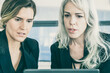 © Mangostar - Focused female project managers staring at laptop display and talking. Front view. Teamwork and communication concept