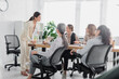 © LIGHTFIELD STUDIOS - demanding team leader standing near multicultural businesswomen during meeting in office
