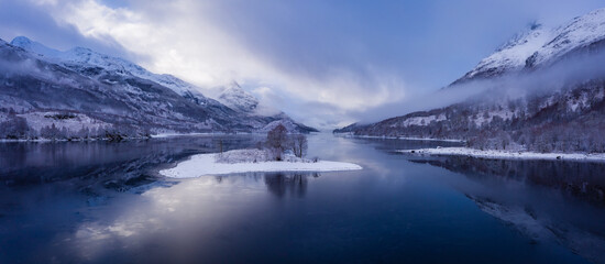 aerial view of a remote scottish island on a sea loch in the argyll region of the highlands of scotland during a snow storm in winter