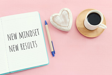 Poster - top view image of table with open notebook and the text new mindset new results. success and personal development concept