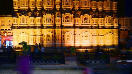 Wall Mural - Jaipur, India time-lapse. Illuminated Palace of Winds Hawa Mahal in Jaipur, India at night. Popular touristic landmark, car traffic trails, souvenir shops, dark blue sky. Nightlife in India