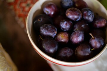 plums in a bowl on the table. organic tasty fruits from the orchard