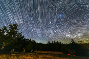 Wall Mural - the earth rotation as seen in the night sky with the star trails. an awe scenery in the outdoors wit