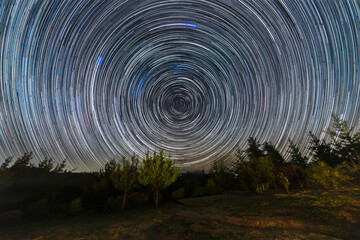 Wall Mural - the earth rotation as seen in the night sky with the star trails. an awe scenery in the outdoors wit
