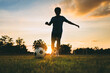 Action sport outdoors of a group of kids having fun playing soccer football for exercise in community rural area under the twilight sunset.