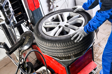 Poster - Mechanic changing tire in car service center.