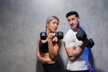 blonde girl and brunette boy training in the gym