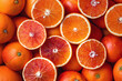 Many blood oranges, whole and halved