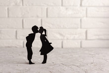 Black Silhouette Of A Boy And A Girl In Love Against A White Brick Wall, Used As A Backdrop