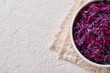 Fermented purple cabbage in a white bowl on a bright background with copy space