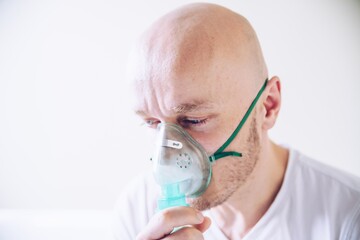 coronavirus sick man breathing with oxygen mask. patient in hospital. breathing problems