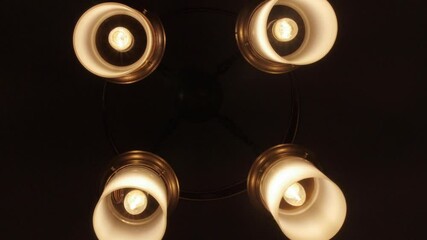 Sticker - A low angle shot of a modern chandelier blinking in the dark in 4K