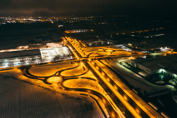 Wall Mural - Aerial view of the trucks unloading at the logistic center. Night view with a bit of snow.