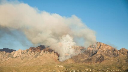 Wall Mural - Day to Night Timelapse of Wildfire. Dense Smoke in Clear Sky and Burning Flames on Hill of Santa Catalina Mountains, Arizona USA