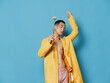 © SHOTPRIME STUDIO - Asian guy with a flower in his hands and a yellow coat blue background