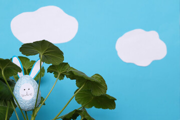 Poster - easter eggs, hare egg hidden in the leaves of grass against the background of the sky with clouds