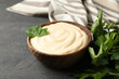 Bowl with mayonnaise, parsley and towel on dark background