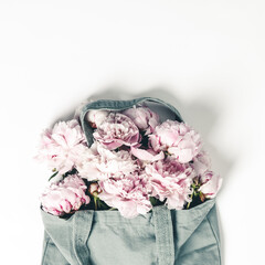 Wall Mural - blue cotton eco tote bag with peony flowers on white background, flat lay