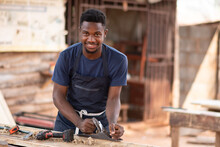 Young African Carpenter Smiling While Working