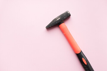 Orange hammer on pink background