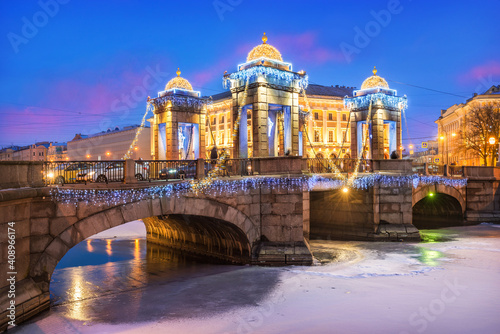 Lomonosov Bridge over the Fontanka River and New Year's decorations in the sky of St. Petersburg © yulenochekk