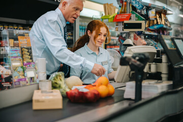 Wall Mural - Manager teaching new employee at supermarket