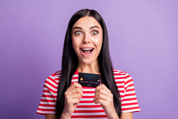 Wall Mural - Photo of amazed happy crazy girl hold credit card spend savings isolated on purple color background