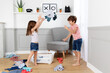 © Lisa Tichané - Young siblings throwing clothes in the air from laundry basket
