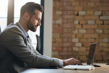 Office worker in grey suit typing on the keyboard