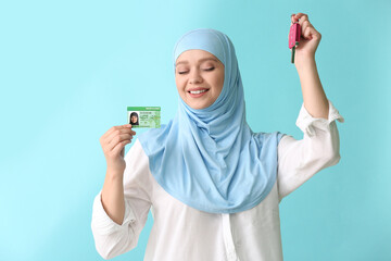 Poster - Happy Muslim woman with driving license and car key on color background