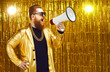 Marketing, sales and discounts concept. Man in shiny jacket, gold chain and sunglasses shouting in megaphone. Movie director or music producer with loudspeaker announces start of casting or audition