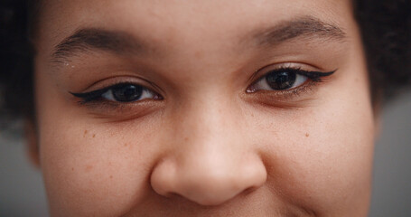 Close up portrait of young african woman smiling at camera isolated on gray background