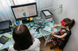 © David Pereiras - Top view of woman teleworking with her daughter drawing side by side