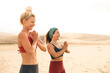 © merla - Two sportive women meditating and doing yoga at the beach