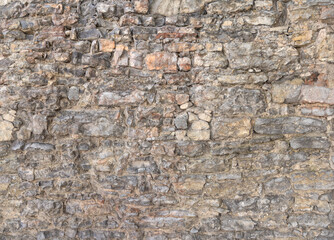 Alte graue Mauer aus vielen, unterschiedlich großen Natursteinen