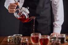 Barista Pouring Rooibos Tea Into Glass Cups From A Teapot