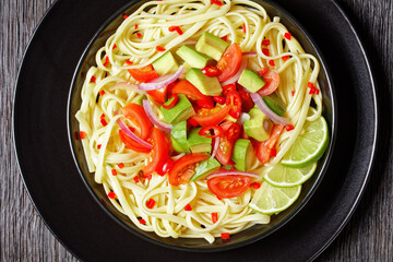 Wall Mural - pasta with avocado, tomatoes and lime, top view